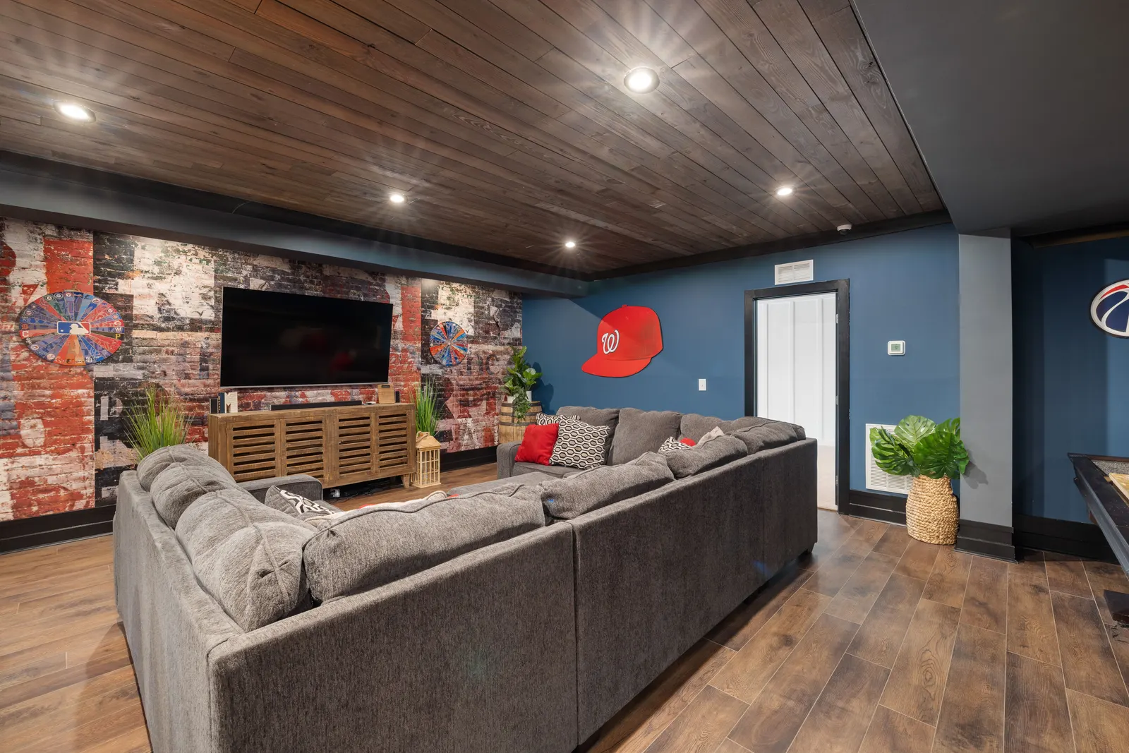 Finished basement family room with sectional, wood ceiling and recessed lighting