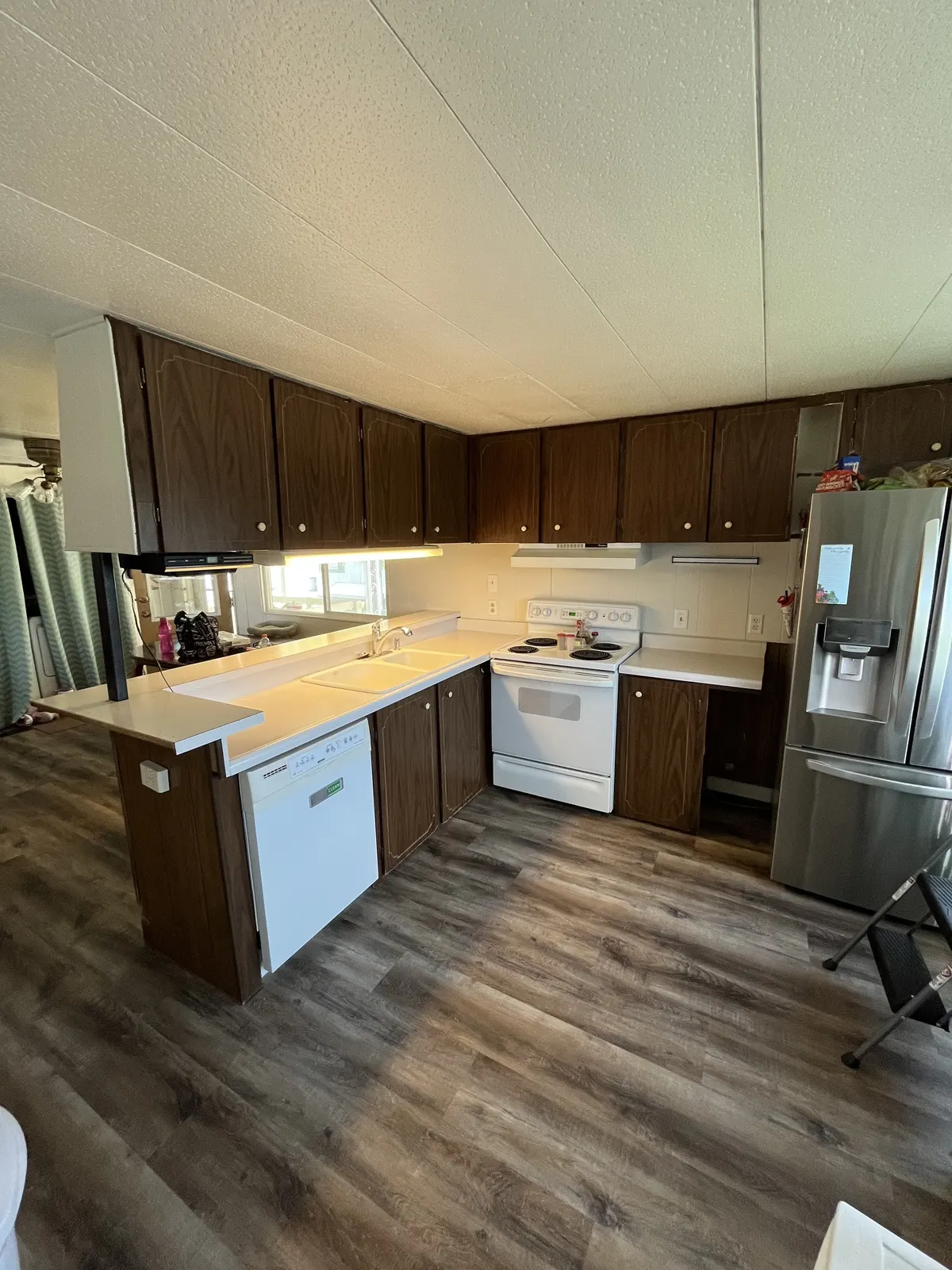 Finished kitchen with dark cabinets, new counters and vinyl plank flooring